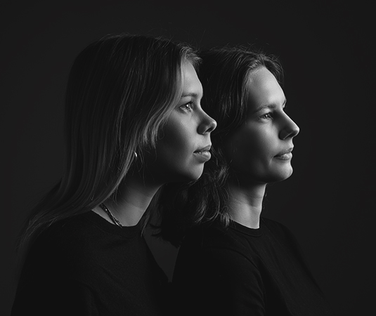 Zwart-wit zijaanzicht portret van twee volwassen zussen in de studio in Leeuwarden