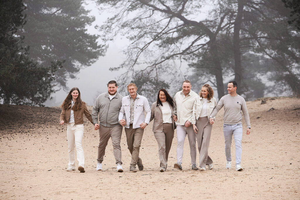 familie loopt hand in hand door de Kale Duinen tijdens fotoshoot in Bakkeveen
