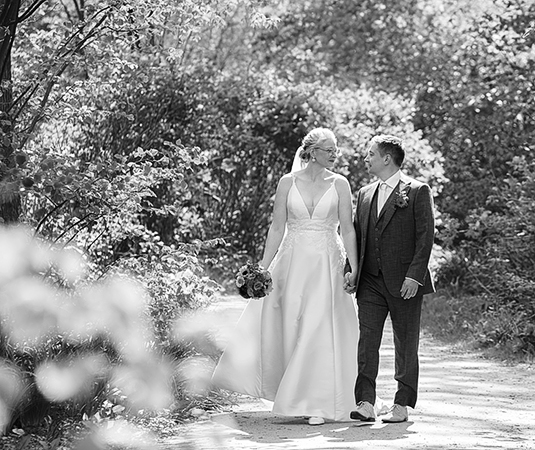 bruiloft Ingeborg en Thijs wandelen samen De Vijverberg Tytsjerk Friesland zwart wit