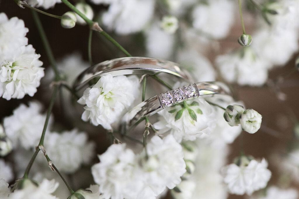 Twee elegante trouwringen genesteld in witte gipskruidbloemen.