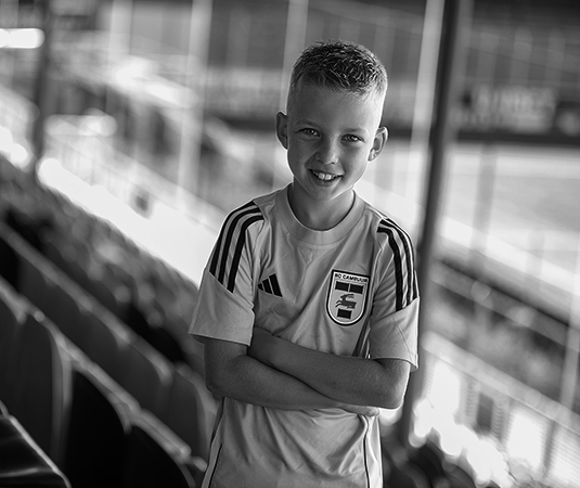 Justin poseert in het Cambuur stadion op de tribune. De foto is zwart Wit.