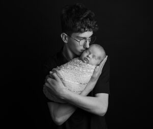 Trotse grote broer kust zijn pasgeboren zusje tijdens een newbornshoot in Leeuwarden - Fotografe Christha